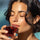 Eine Frau trinkt einen Shot mit roten Kollagendrink von Inner Radiance