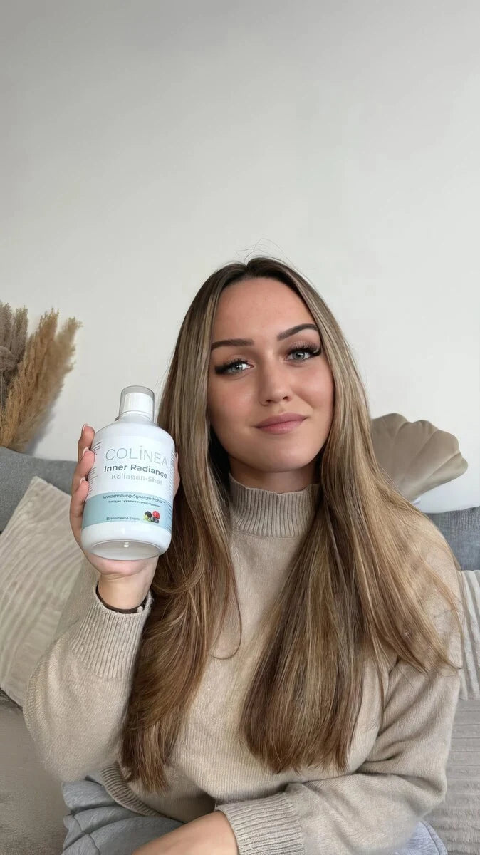 Schöne Frau mit einer Flasche Colinea Inner Radiance in der Hand die sie lächelnd in die Kamera zeigt
